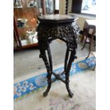 A Chinese hardwood vase stand with inset rouge marble top, flower carved frieze, on slender legs