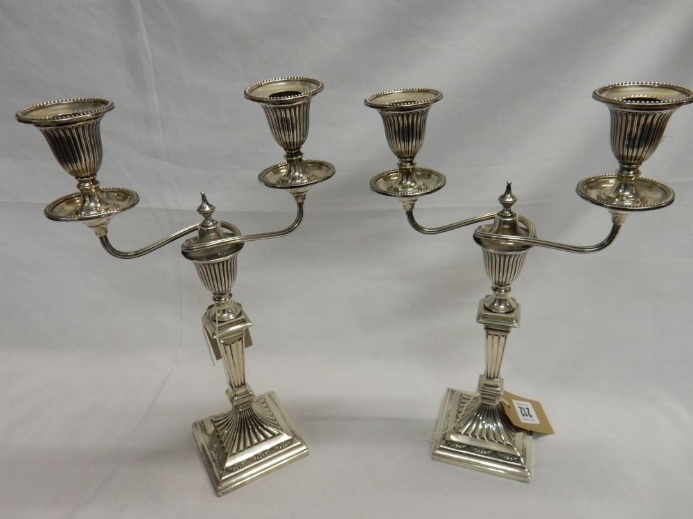 A pair of Victorian silver twin branch candelabra with fluted urn form decoration, on tapering