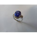 A lady's ring set tanzanite surrounded by diamonds, baguette and brilliant cut diamonds to the