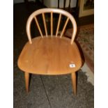 A low Ercol elm chair with curved back, hard seat, on turned legs