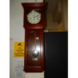 A reproduction wall clock with silvered dial, striking movement, in a mahogany case with glass