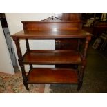 A Victorian oak three tier buffet with low raised back, on carved and turned supports terminating in