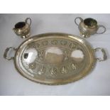 An Indian silver coloured metal double handled tray, matching cream jug and sugar basin, all with