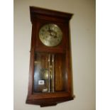 A wall clock with silvered dial, in an oak and glass panelled case