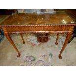 A reproduction walnut sidetable with rope carved edge, on slender cabriole legs terminating in