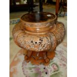 A Chinese vase stand with pierced decoration of flowers and leaves, on scroll legs united by