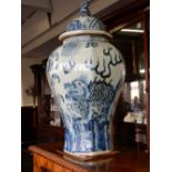 A pair of Oriental blue and white jar and covers decorated coiling dragons - 23in. high