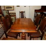 An oak drawleaf dining table on carved bulbous legs, a set of five (including one carver) oak framed