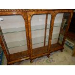 A reproduction walnut breakfront bookcase with fluted edge, fitted three glass doors and sides, on