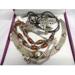 An Eastern silver collar necklace, a silver and amber long necklace, a necklace with tassel fob, a