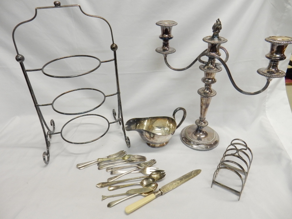 A selection of silver plate including a three branch candelabra, oval tray, sauce boat, cake stand