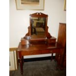 An Edwardian mahogany dressing table, the raised back fitted mirror and two jewel drawers, the