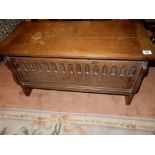 A reproduction oak small coffer with hinged lid, carved panelled front - 31in. wide