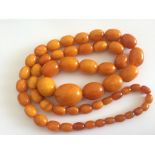 String of Egg Yolk Amber Beads 770mm long and weighing 73 grams with largest bead approx 27mmx22mm.