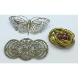 A Victorian red stone and gilt brooch, stones a/f, and two white metal brooches,