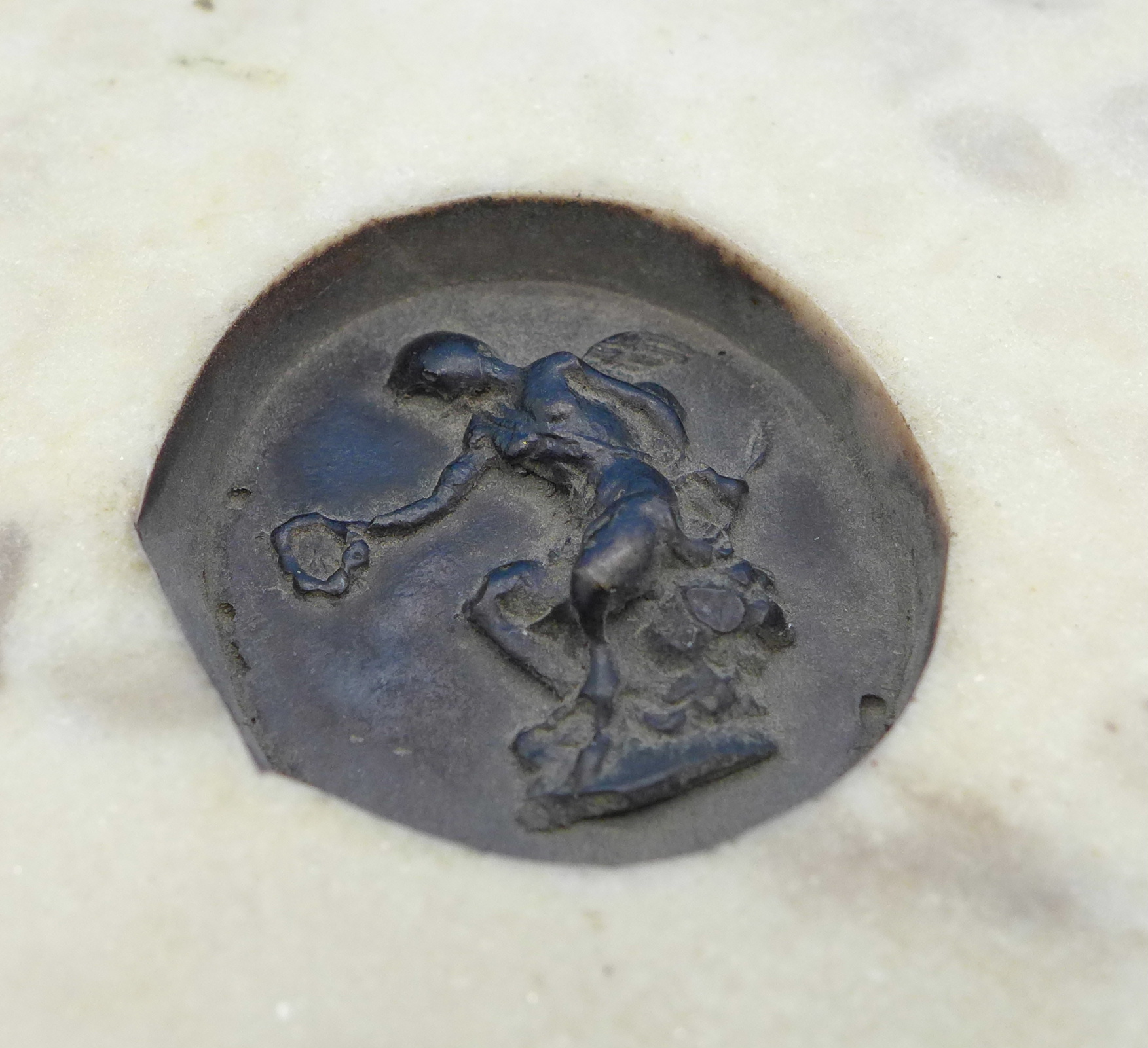 A bronzed plaque depicting three cupids on a reconstituted stone circular surround, - Image 2 of 3