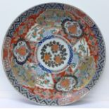 A large Imari charger decorated in red, blue, green and gold glazes on a white ground,