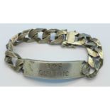 A silver ID bracelet with inscription,