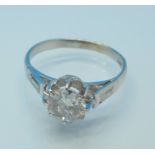 A platinum set Art Deco diamond solitaire ring with diamond baguette shoulders, c.