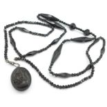 A Victorian locket on a black bead chain,