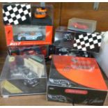 Five die-cast motor racing cars and two replica helmets,