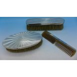 Two silver and enamel brushes and a comb,