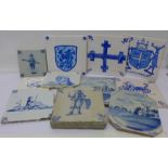 A collection of tiles, five blue and white tiles including Delft,