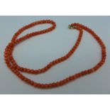 A coral bead necklace with 9ct gold fastener