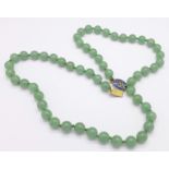 A green stone necklace with enamel clasp