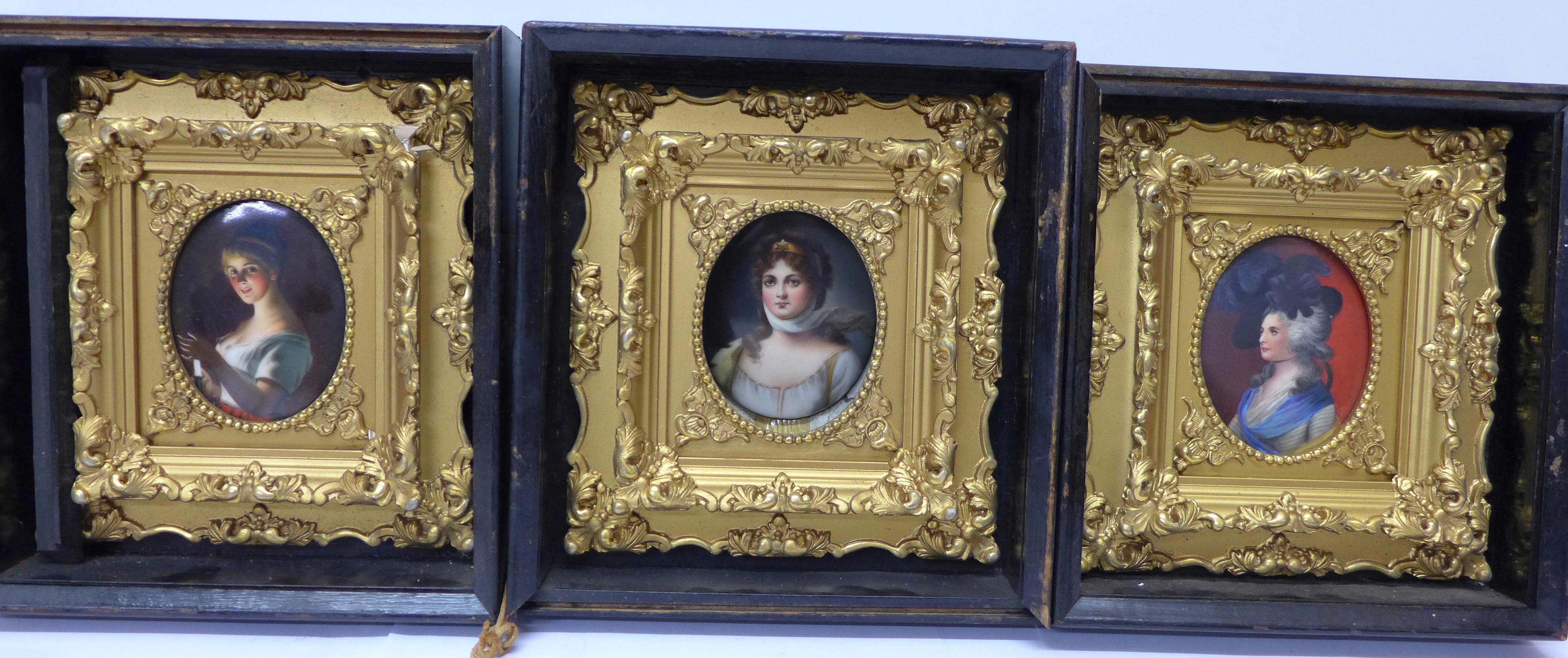 A set of three early 19th Century portrait miniatures of ladies, oval quarter length, on porcelain,