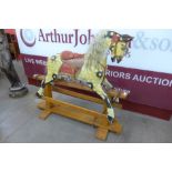 A vintage dapple grey rocking horse on wooden stand