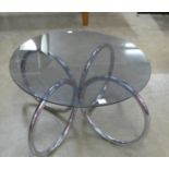 A chrome and circular glass topped coffee table