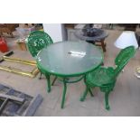 A painted metal and glass garden table and two chairs