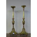 A pair of Italian brass and copper alter candle stands