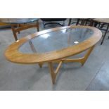 An oval teak and glass coffee table