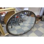 A Victorian Aesthetic Movement ebonised and parcel gilt oval mirror