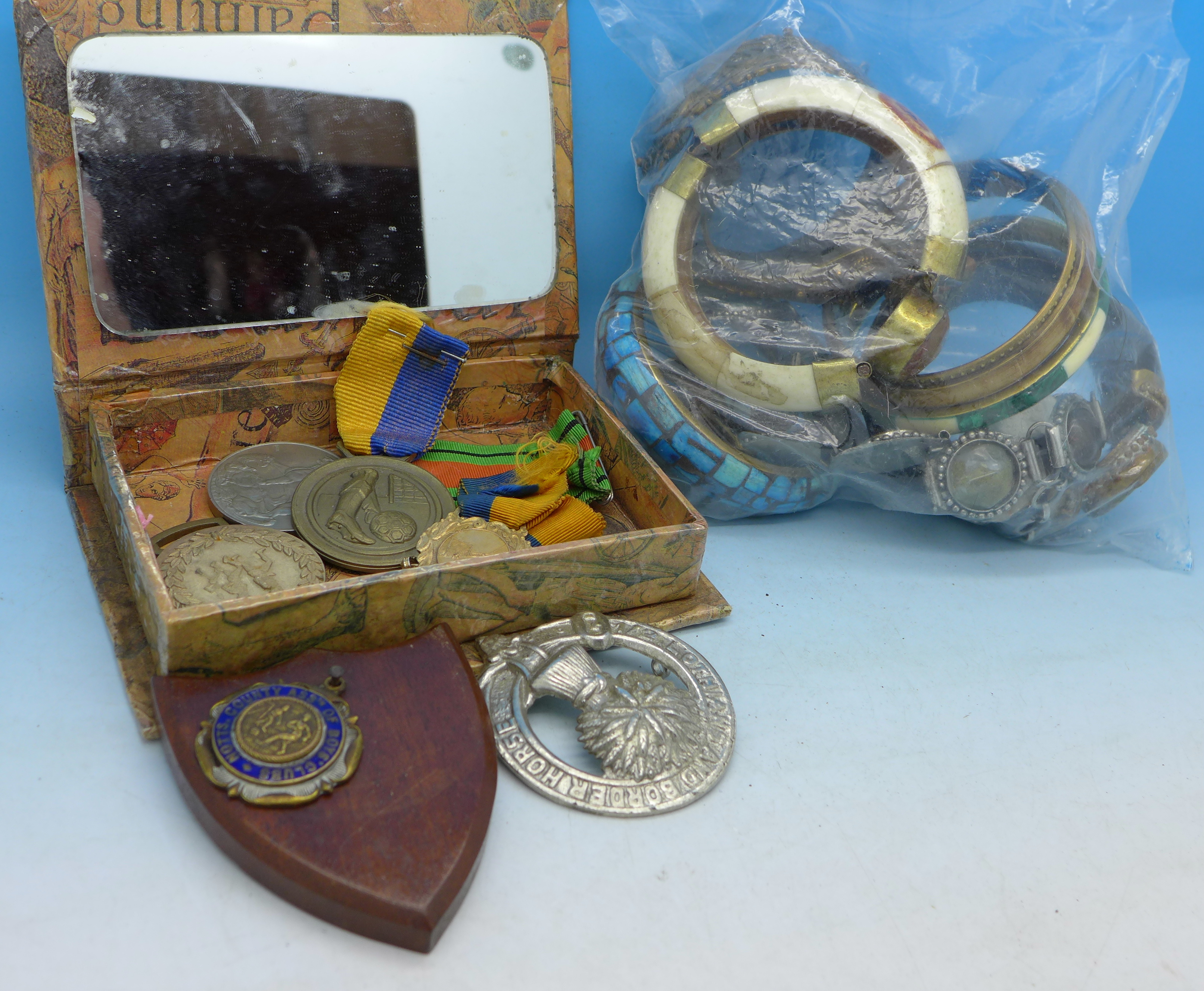 A WWII medal, other medallions, bangles, etc.