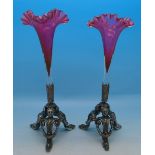 A pair of cranberry glass trumpet vases on plated stands, bottom of one vase a/f, height 18.
