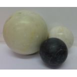 A large alabaster ball and two other stone balls