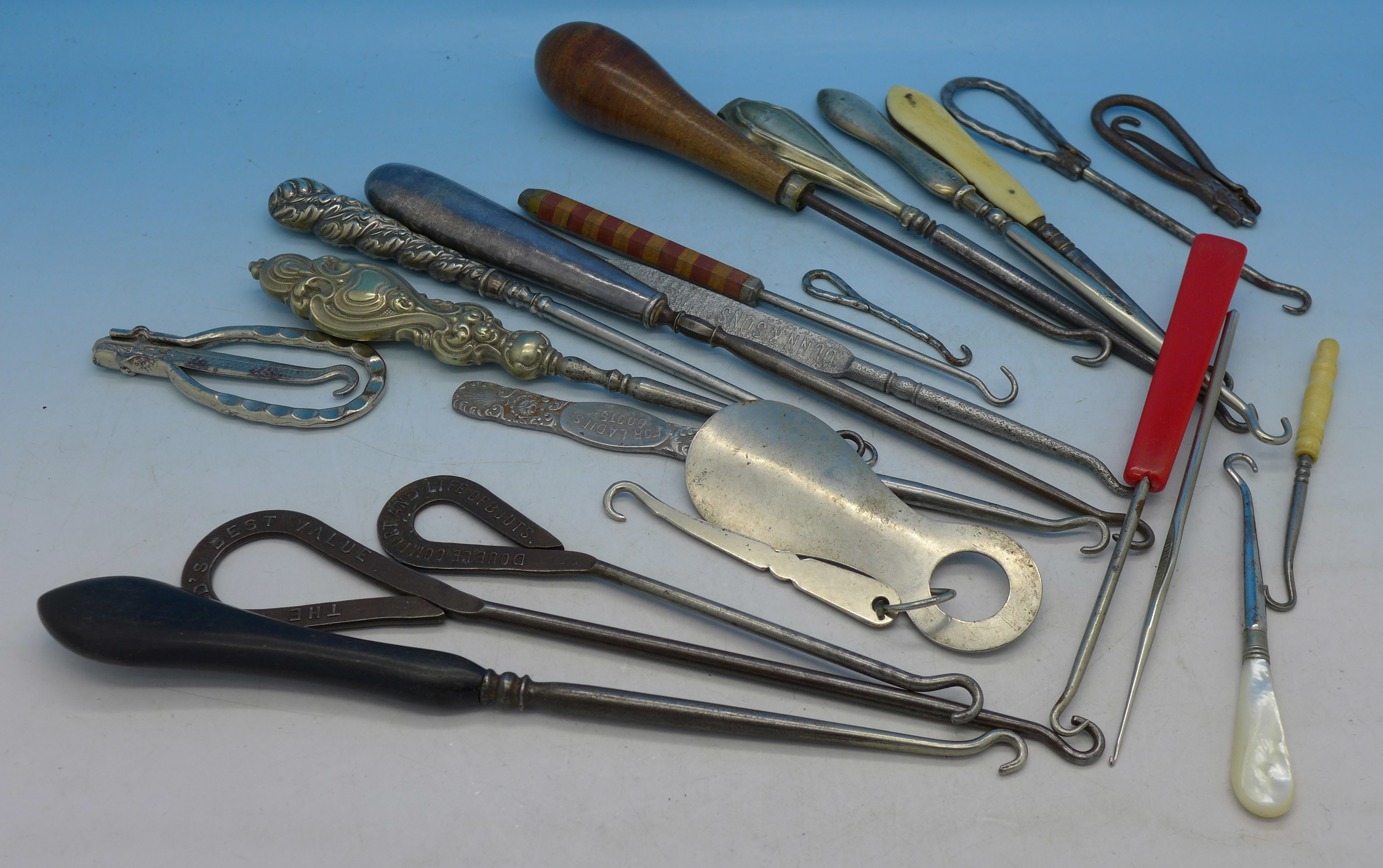 A collection of button hooks including silver handled and advertising