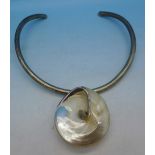 A silver choker necklet with silver and mother of pearl pendant
