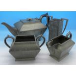 A hammered pewter Arts and Crafts four-piece tea service by Civic England