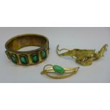 A plated bangle set with green glass stones,