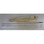 An Alex Martin split cane fishing rod with canvas bag and spare whip end piece