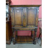 A George III style oak cupboard on stand