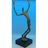 A metal abstract figure of a tennis player on stand,