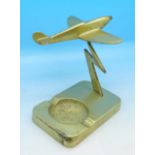 A brass model of a Spitfire with ashtray