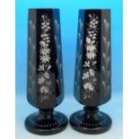 A pair of black glass vases with applied enamel decoration,