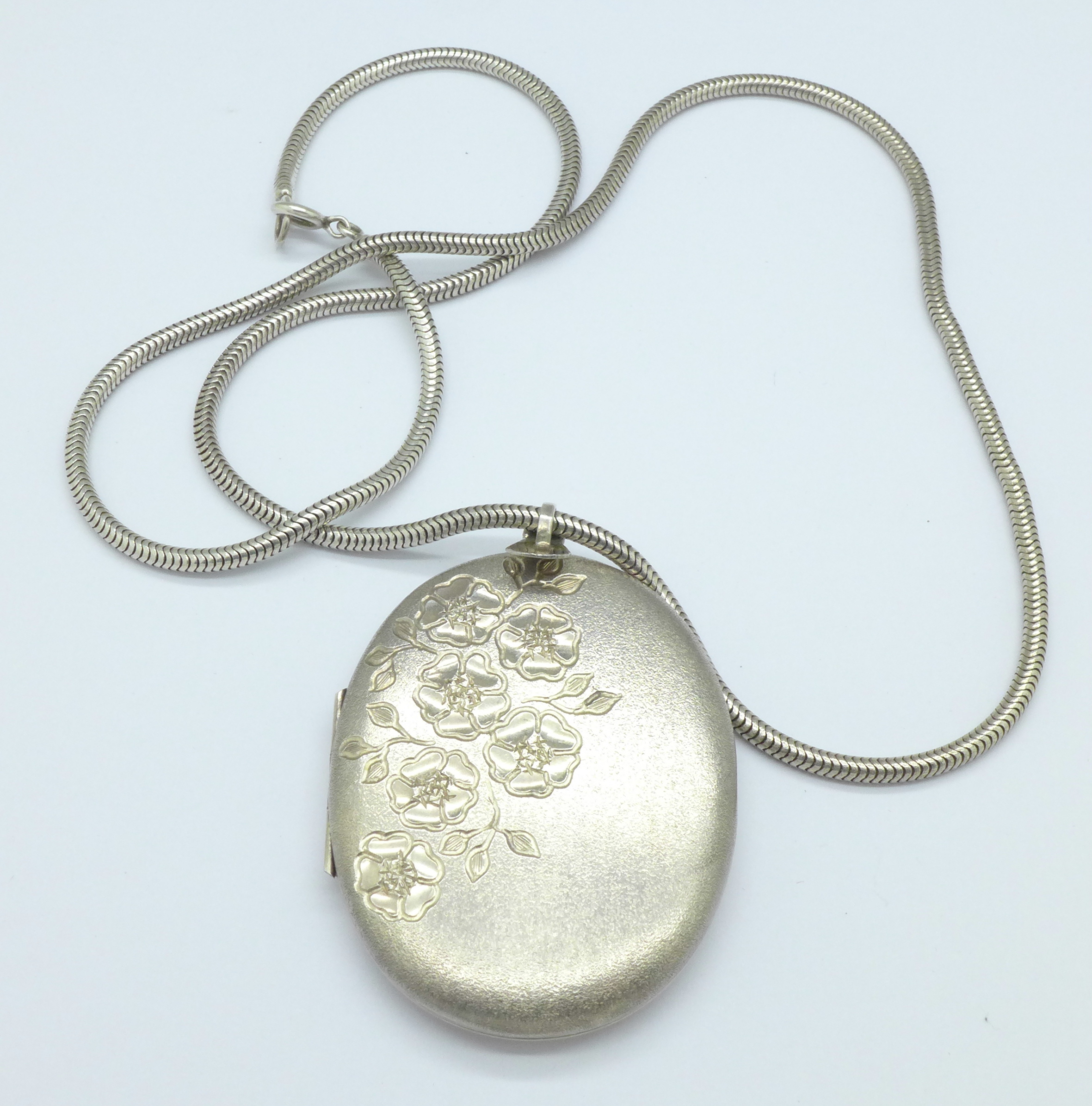 A large hallmarked silver locket on a silver chain,