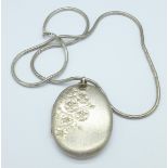 A large hallmarked silver locket on a silver chain,